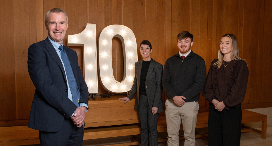 10 year lit up sign to celebrate the 10 year financial times rankings with Professor Anthony Brabazon, Dean of UCD College of Business; Professor Federica Pazzaglia, Director of UCD Smurfit School; students James Burke and Lauren Dufficy.